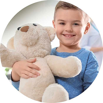 Kleiner Junge hält einen Teddybär und lacht
